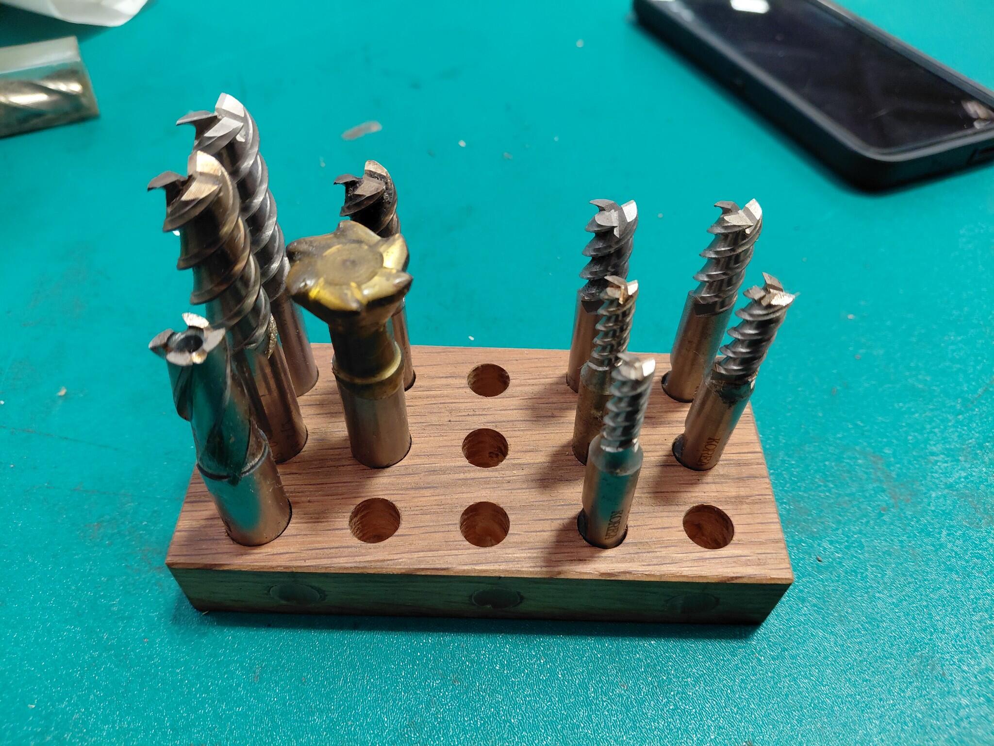 Assorted countersinks and end mills on wooden block
